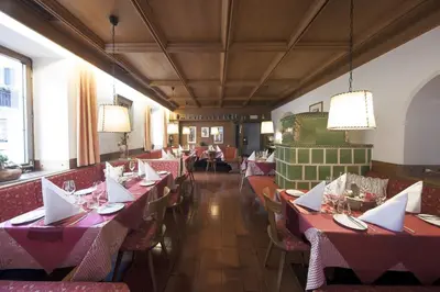 a dining room with red tables and chairs at Gasthof Moarwirt in Colle Isarco