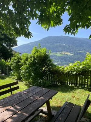 a wooden picnic table with a view of the mountains at Obermairhof in Parcines