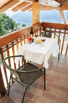 a table with two glasses of wine on a balcony at Obermairhof in Parcines