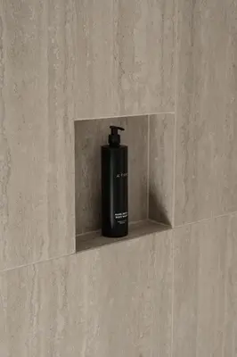 a black bottle sitting on a shelf in a wall at Anett hotel in Vipiteno