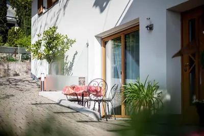 a table and chairs sitting outside of a building at Gästehaus Pfuss in Caldaro