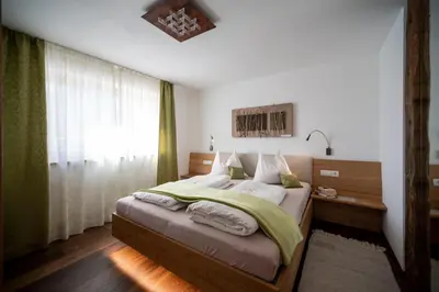 a bedroom with a large bed and a window at Gästehaus Pfuss in Caldaro