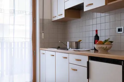 a kitchen with white cabinets and a sink at Ferienwohnung im Haus Texel V in Parcines