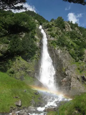 a waterfall with a rainbow on the side of a mountain at Ferienwohnung im Haus Texel V in Parcines