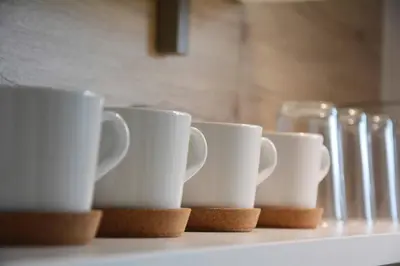 a row of white cups sitting on a shelf at Appartement Karnutsch in Schenna