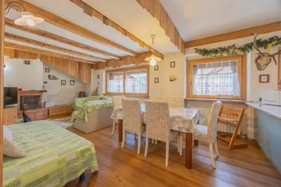 a kitchen and living room with a table and chairs at Ciaseles a due passi da Cortina d'Ampezzo in San Vito di Cadore