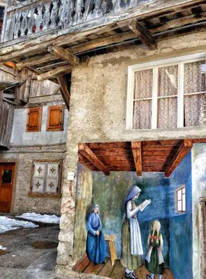 a painting of two women on the side of a building at Ciaseles a due passi da Cortina d'Ampezzo in San Vito di Cadore