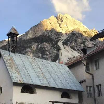 a church with a mountain in the background at Ciaseles a due passi da Cortina d'Ampezzo in San Vito di Cadore