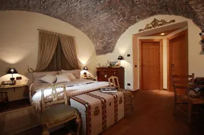 a bedroom with a large bed and a stone wall at Maso Valfloriana in Valfloriana