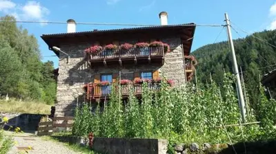 a house with a balcony with flowers on it at Maso Valfloriana in Valfloriana