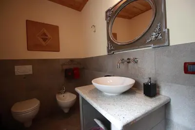 a bathroom with a sink and a toilet and a mirror at Maso Valfloriana in Valfloriana