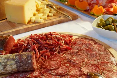 a plate of food with meat and vegetables and cheese at Ciasa Roby in San Cassiano