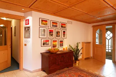a room with pictures on the wall and a table at Ciasa Roby in San Cassiano