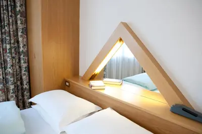 a mirror in a room with two beds and a window at Ciasa Roby in San Cassiano