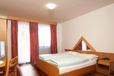 a bedroom with a bed and a large window at Ciasa Roby in San Cassiano