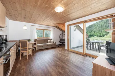 a kitchen and living room with a couch and a table at Appartements Toni in Feldthurns