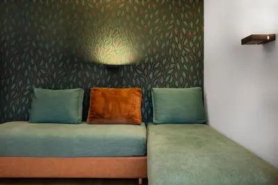 a couch with two pillows on it in a room at Ciasa Milandura NEW SUMMER 2025 in San Cassiano