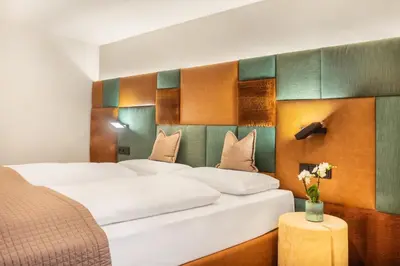 a hotel room with two beds and a table with flowers at Ciasa Milandura NEW SUMMER 2025 in San Cassiano