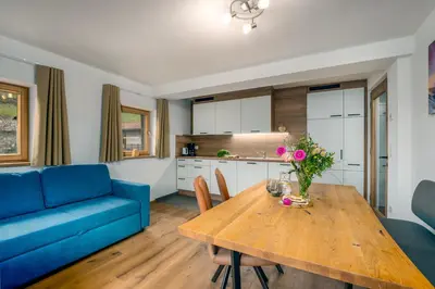 a living room with a table and a blue couch at Pardellerhof Lüsen in Luson
