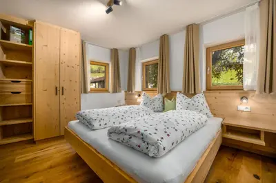 a bedroom with a large bed with pillows on it at Pardellerhof Lüsen in Luson