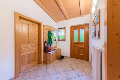 a bathroom with wooden doors and a tiled floor at Pardellerhof Lüsen in Luson