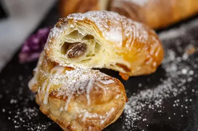 two pastries on a table with powdered sugar at Pardellerhof Lüsen in Luson