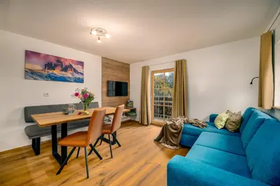 a living room with a blue couch and a table at Pardellerhof Lüsen in Luson