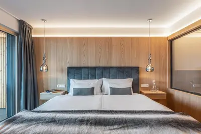 a bedroom with a large bed and two lamps at Dornsberg Panoramic Apartments in Schenna