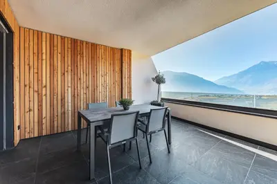 a dining room with a table and chairs and a view at Dornsberg Panoramic Apartments in Schenna