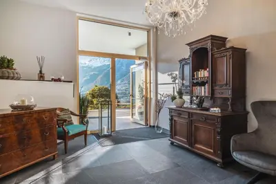 a room with a desk and a chandelier at Dornsberg Panoramic Apartments in Schenna