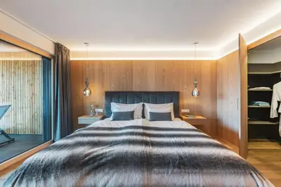 a bedroom with a large bed with wooden walls at Dornsberg Panoramic Apartments in Schenna
