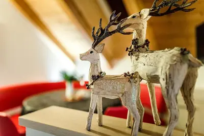 a wooden figurine of a deer on a table at Taela Apartments in San Cassiano