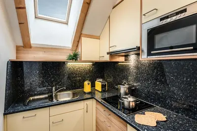 a kitchen with a sink and a stove at Taela Apartments in San Cassiano