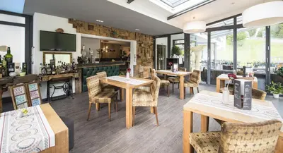 a restaurant with tables and chairs and windows at Hotel Florian in Selva di Val Gardena