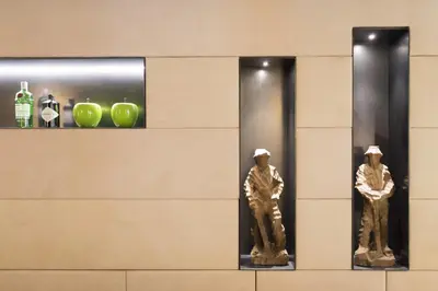 two statues of men are in a wall at Hotel Florian in Selva di Val Gardena