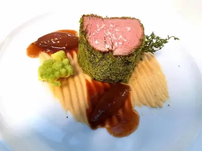 a plate of food with cheese and meat and sauce at Hotel Gschwangut in Lana