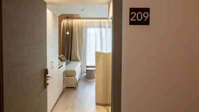 a room with a bathroom with a toilet and a door at Hotel Gschwangut in Lana