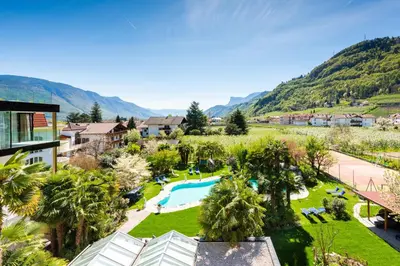 an aerial view of a resort with a swimming pool and mountains at Hotel Gschwangut in Lana