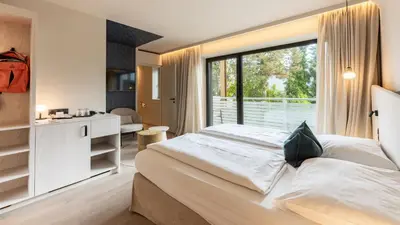 a bedroom with a large bed and a large window at Hotel Gschwangut in Lana