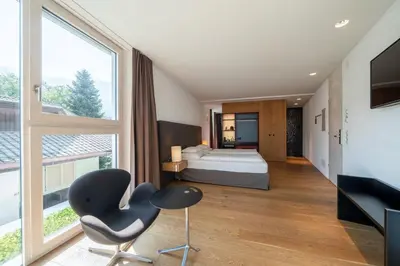 a white bed on a balcony with a potted plant at Soley Suites - adults only in Bressanone