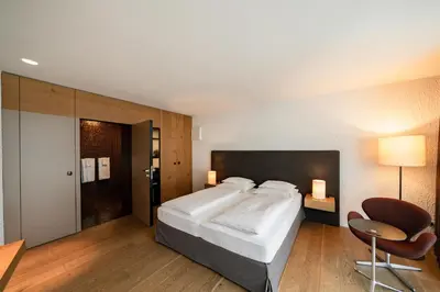 a hotel room with a bed and a desk at Soley Suites - adults only in Bressanone