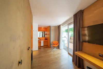 a living room with a television and a chair at Soley Suites - adults only in Bressanone