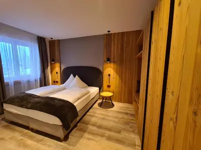 a bedroom with a large bed and a window at Hotel Astoria in Canazei
