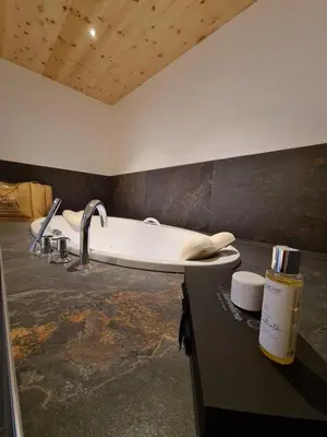 a bathroom with a sink and a bath tub at Hotel Astoria in Canazei
