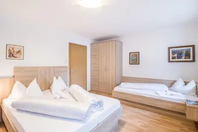 a bedroom with two beds with white pillows at Apartments Heidenberger Fienili in Colle Isarco