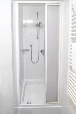 a shower with a glass door in a bathroom at Apartments Heidenberger Fienili in Colle Isarco