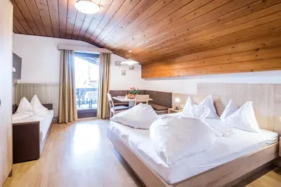 a bedroom with a large bed and a wooden ceiling at Apartments Heidenberger Fienili in Colle Isarco