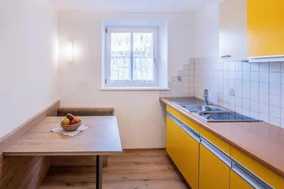 a kitchen with a table with a bowl of fruit on it at Apartments Heidenberger Delle Scuole in Colle Isarco