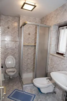 a bathroom with a shower and a toilet and a sink at Apartments Heidenberger Delle Scuole in Colle Isarco