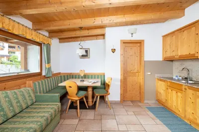 a kitchen and living room with a couch and a table at Frara Residence Apartments in San Cassiano